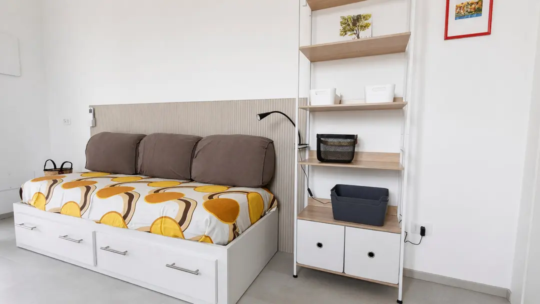 Il soggiorno dell’appartamento Ulivo: il divano letto singolo e la libreria a fianco