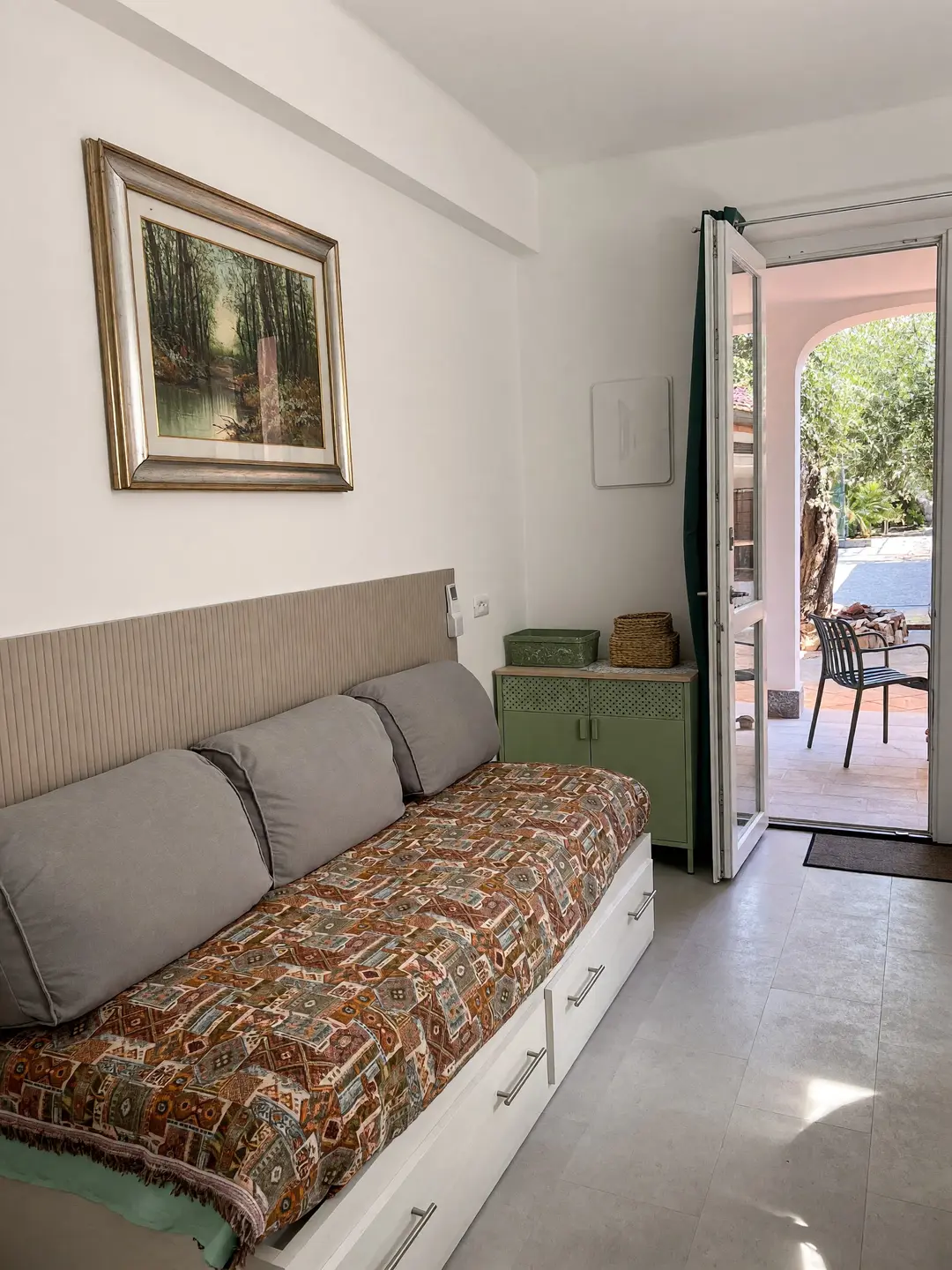 Il soggiorno dell’appartamento Basilico, con il divano letto e la porta aperta sul portico
