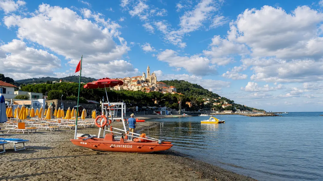 Il pattino del bagnino sulla battigia, con il borgo di Cervo sullo sfondo