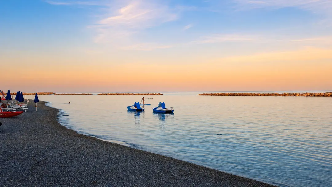 Il tramonto sulla spiaggia, con i pedalò in riva
